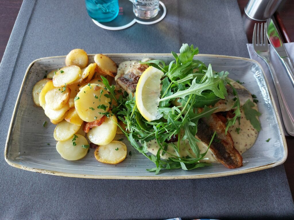 Mecklenburger Pannfisch, gebratenes Nordseedorschfilet an Senfsoße und Bratkartoffeln, Rucolabekrönt