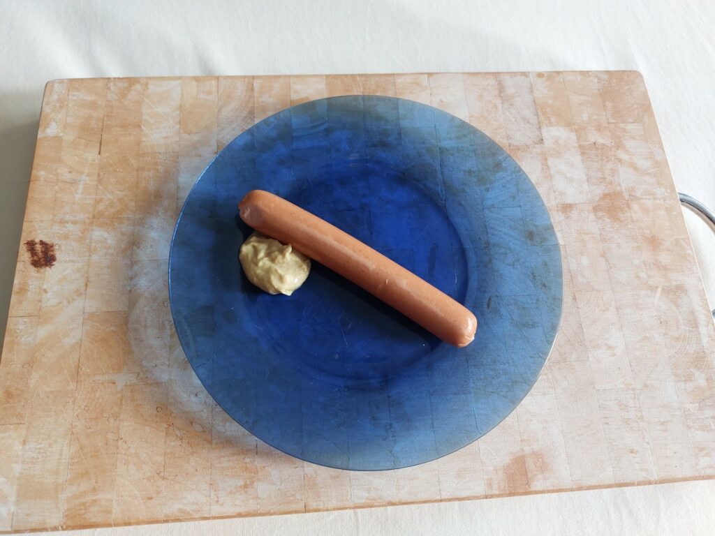 Vegetarische Wiener auf blauem Teller mit Senf