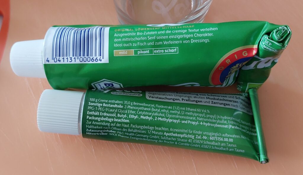 Zwei grüne Tuben, einmal Bio-Senf und einmal Schmerzsalbe