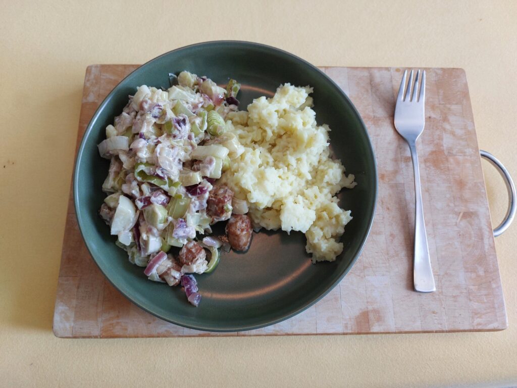 Lauch mit Bratwurst, Zwiebeln und Schmand an Quetschkartoffeln