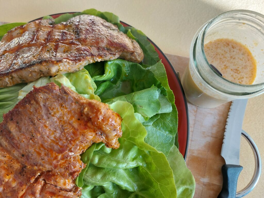Mariniertes Nackensteak auf Kopfsalatblättern, Dressing separat