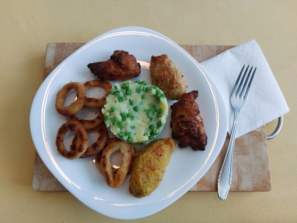 Kartoffelbrei mit Erbsen, Chickenteile, Zwiebelringe