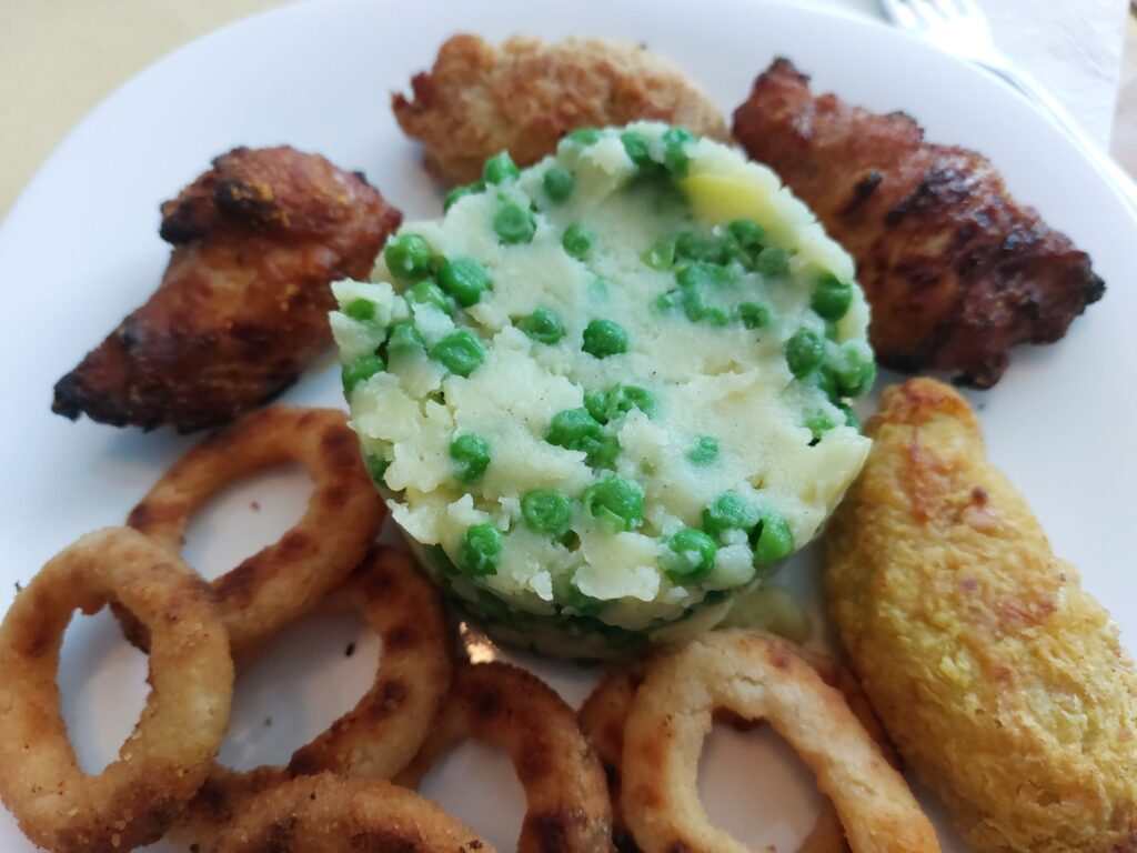 Kartoffelbrei mit Erbsen, Chickenteile, Zwiebelringe