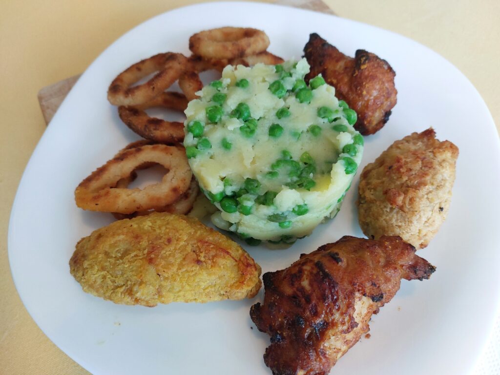 Kartoffelbrei mit Erbsen, Chickenteile, Zwiebelringe