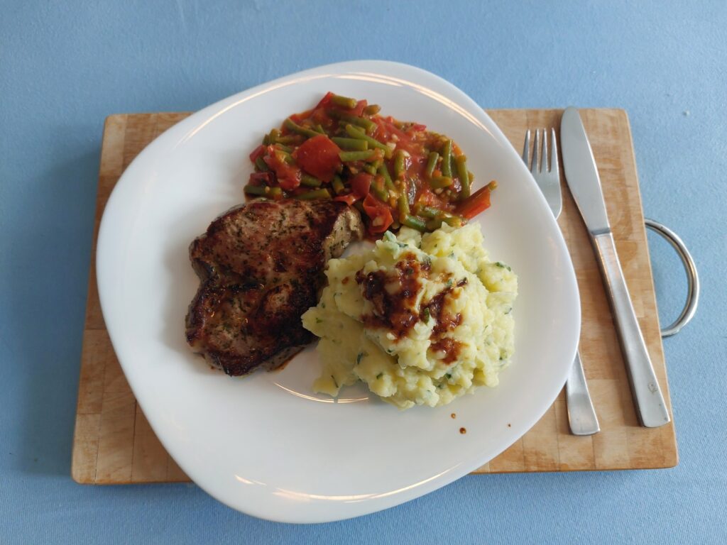 Nackensteak an tomatisierten Bohnen und Kartoffelbrei