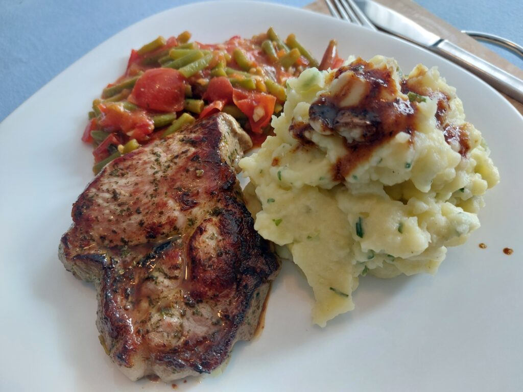 Nackensteak an tomatisierten Bohnen und Kartoffelbrei